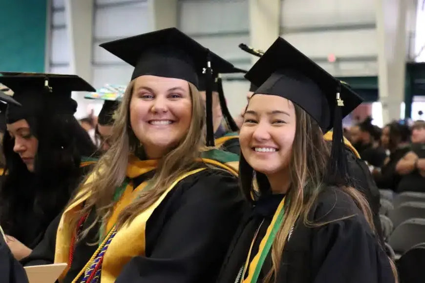 两个微笑的学生在毕业典礼上