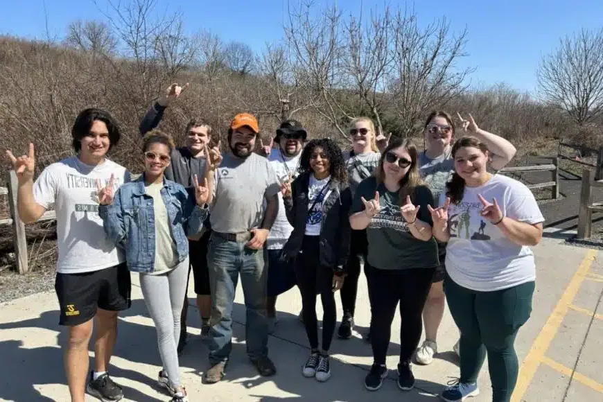 students smiling in a group photo on the alternative spring break trip